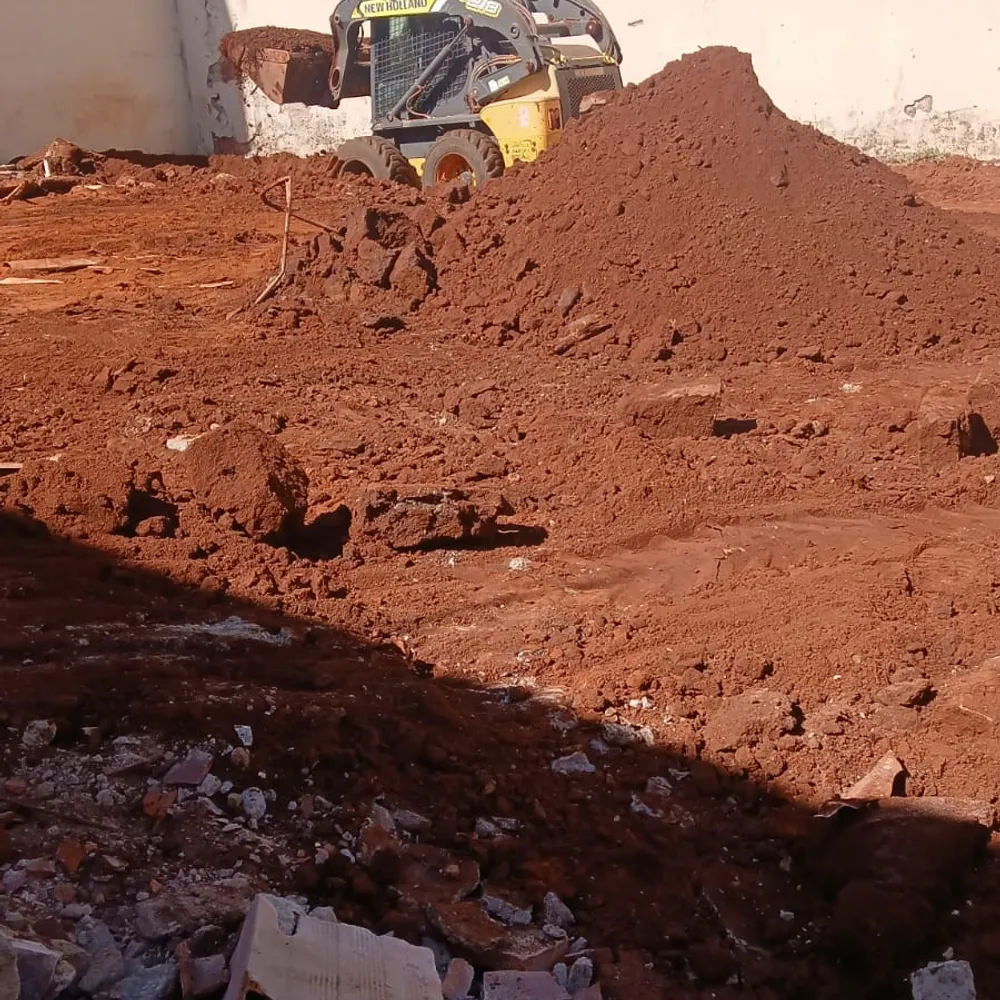 Mini-carregadeira movimentando terra no terreno